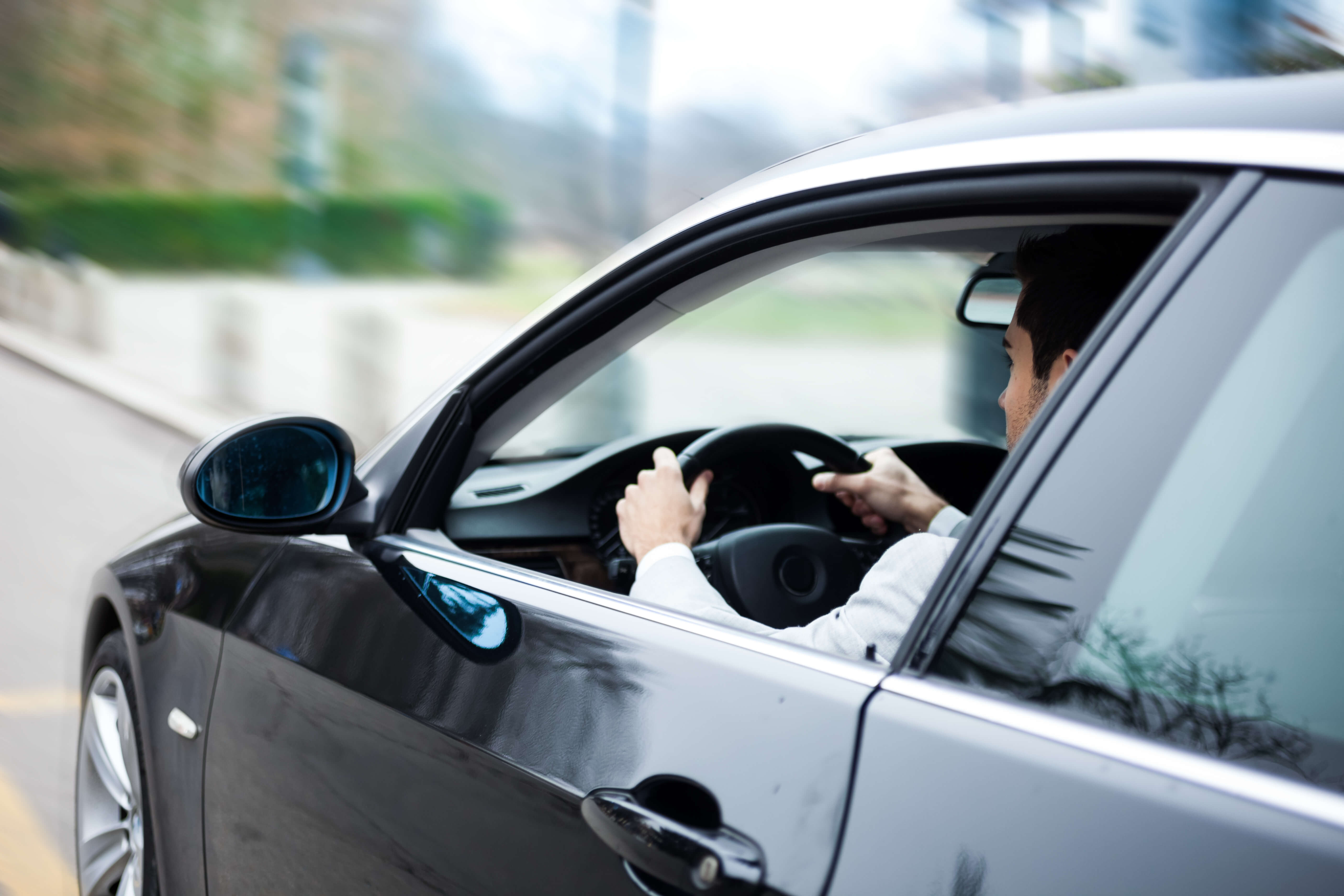 A man driving a sedan